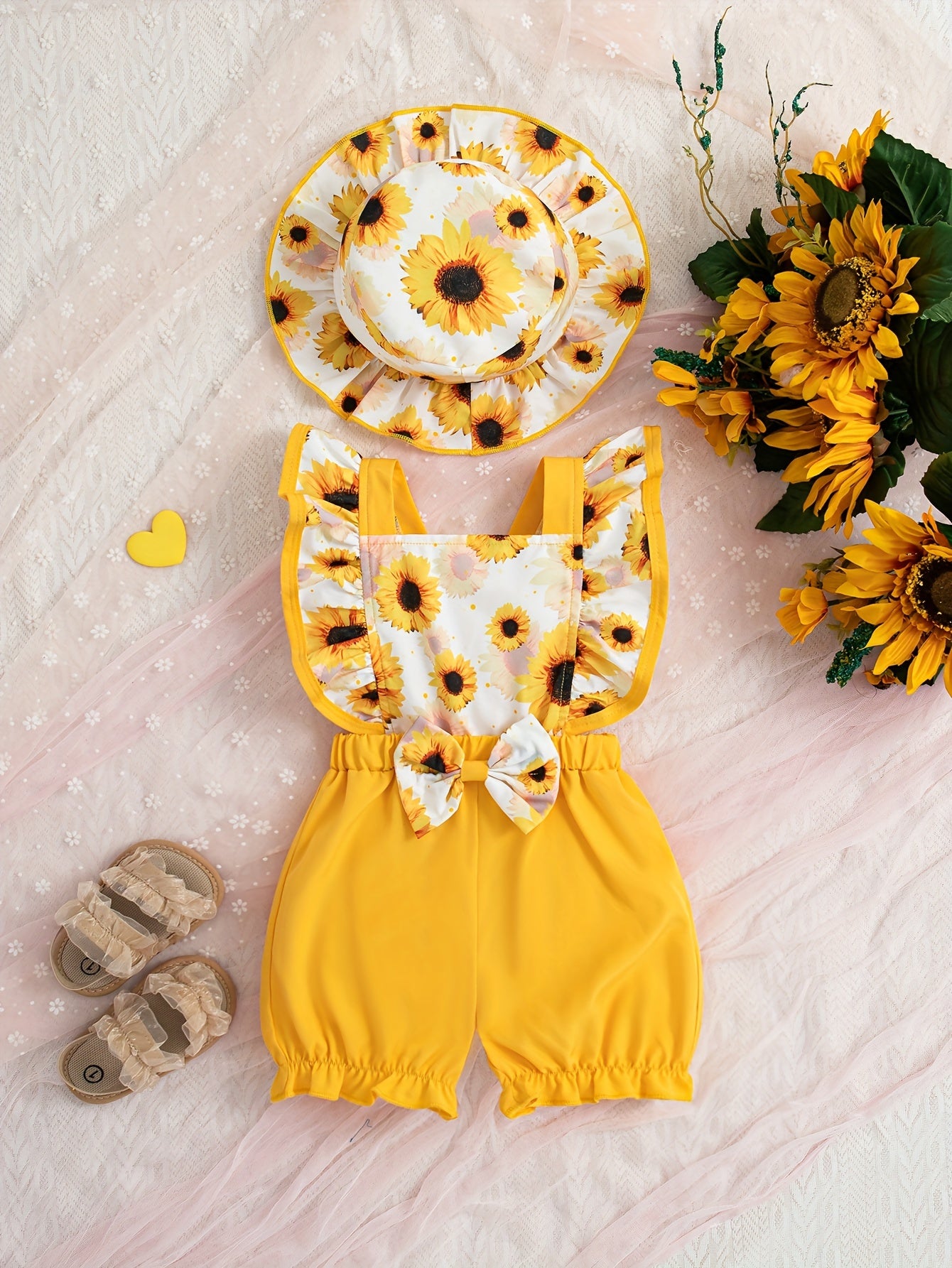 Cute sunflower and butterfly print baby girl jumpsuit with bow detail and matching hat. Made of polyester, machine washable. Perfect for summer and outdoor activities.