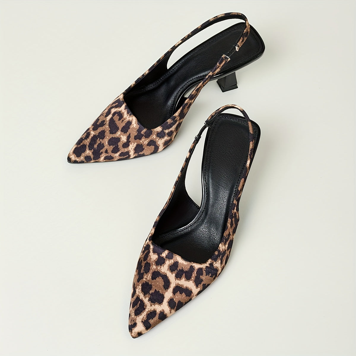 Leopard print stiletto sandals with pointed toe, slip-on style, and high heels in black and brown animal pattern. Comfortable for fall fashion.