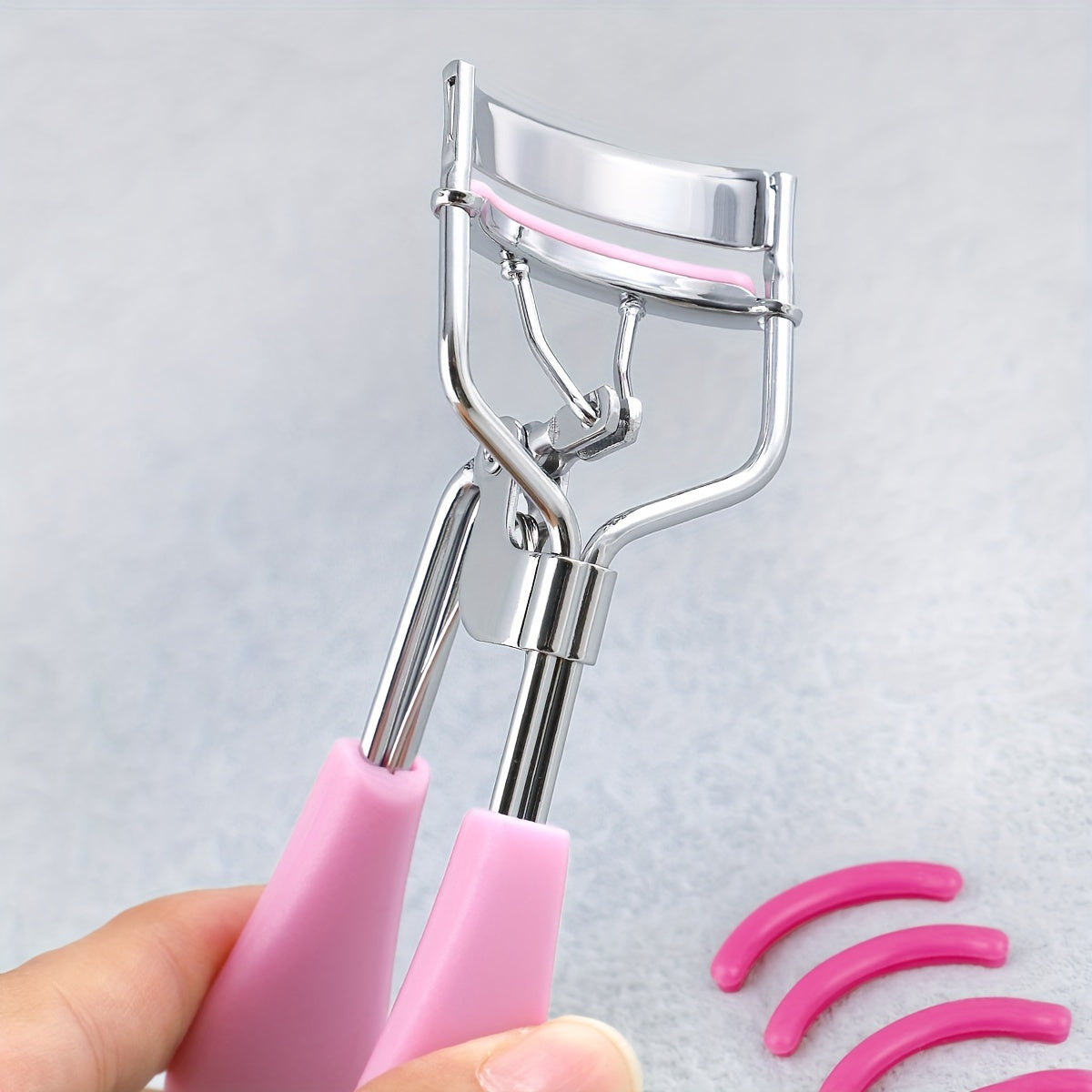 Portable eyelash curler with stainless steel handle, 15 silicone pads for curling and shaping without damaging lashes. Ideal for lifting and creating big, beautiful eyes on women.