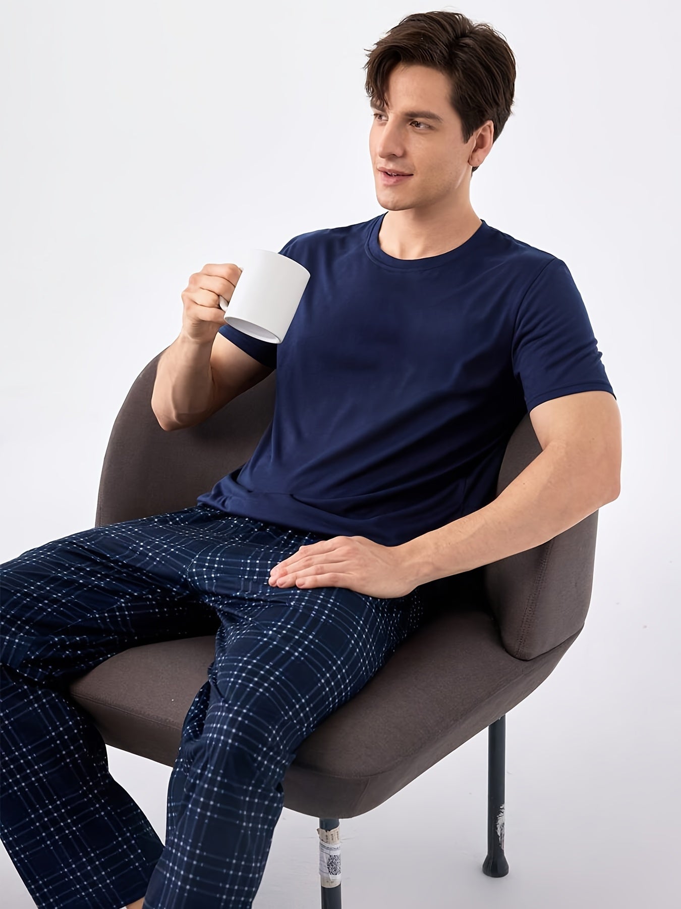 Men's blue pajama set with classic round neck, short sleeves, and plaid trousers for cozy loungewear.