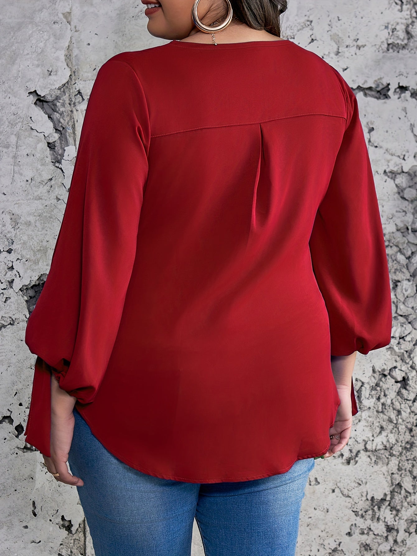 Plus size women's casual top with solid colors, lantern sleeves, round neck, round hem, and knot detail.