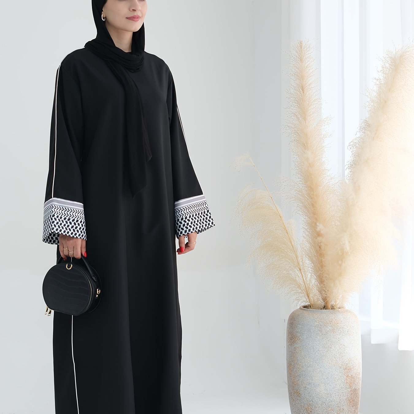 Stylish embroidered zippered abaya dress with long sleeves for Middle Eastern Muslim fashion. Made from polyester knit fabric, part of the spring/fall collection. Features a regular fit and