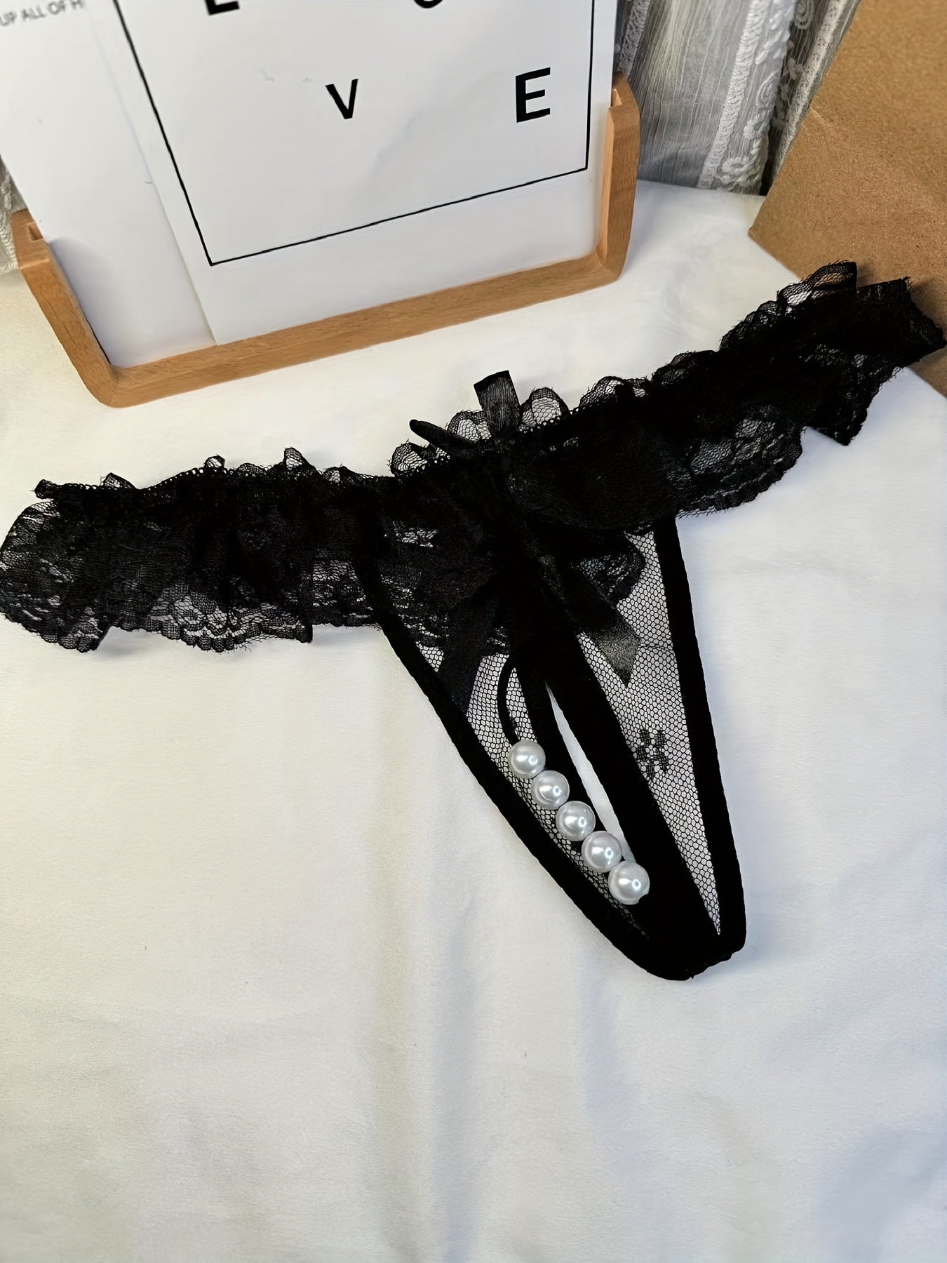 Double-bow, sexy, transparent, hot, lace crotchless thong with pearl massage detail.