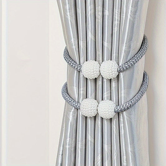 Two pieces of modern style polyester curtain tie backs with a silvery finish. These window drapery holdbacks are perfect for adding a touch of elegance to your home or office decor.