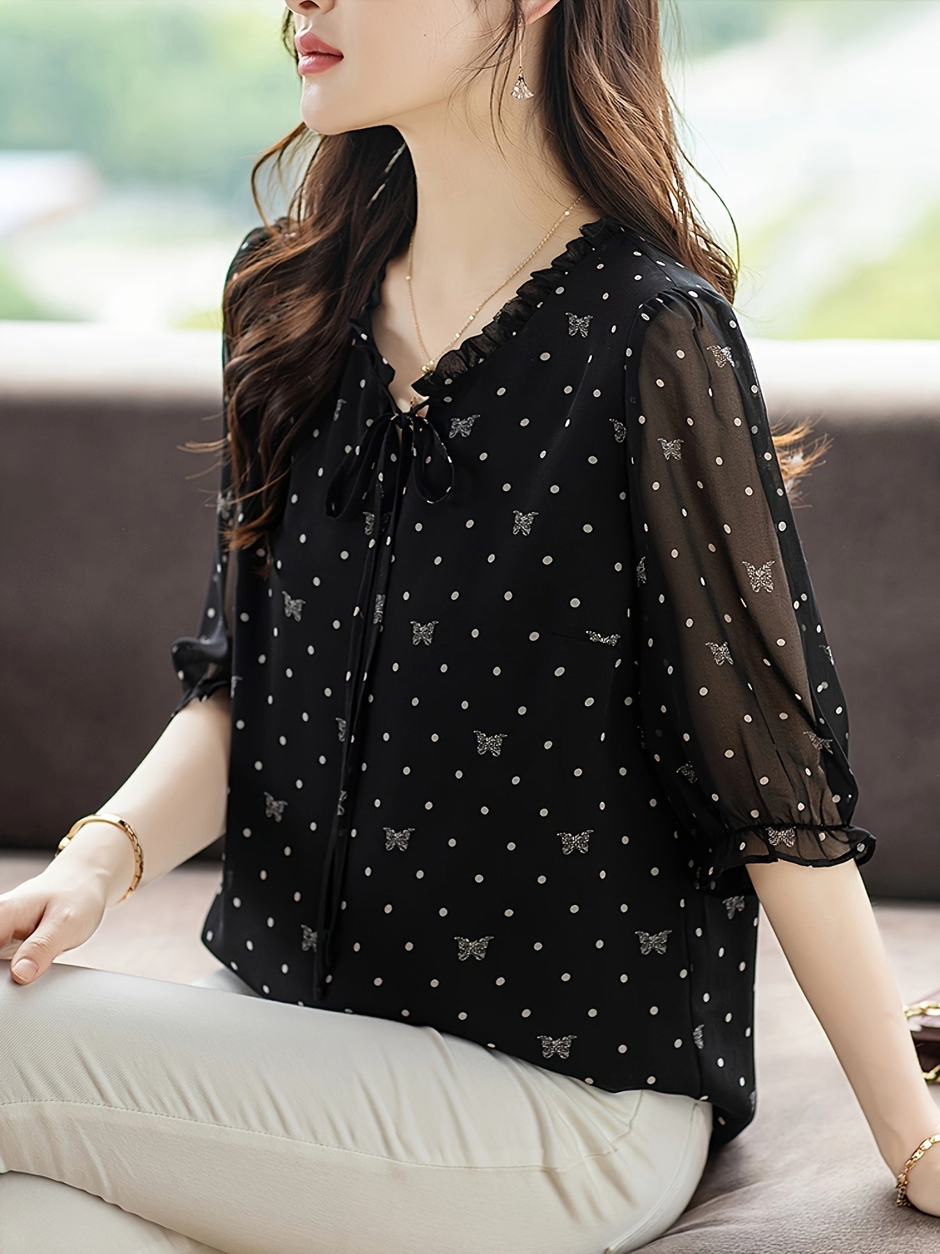 Stylish black floral chiffon blouse with bow tie neckline, sheer sleeves, and non-stretch polyester fabric. Recommended for hand or dry clean only. Ideal for summer 2024.