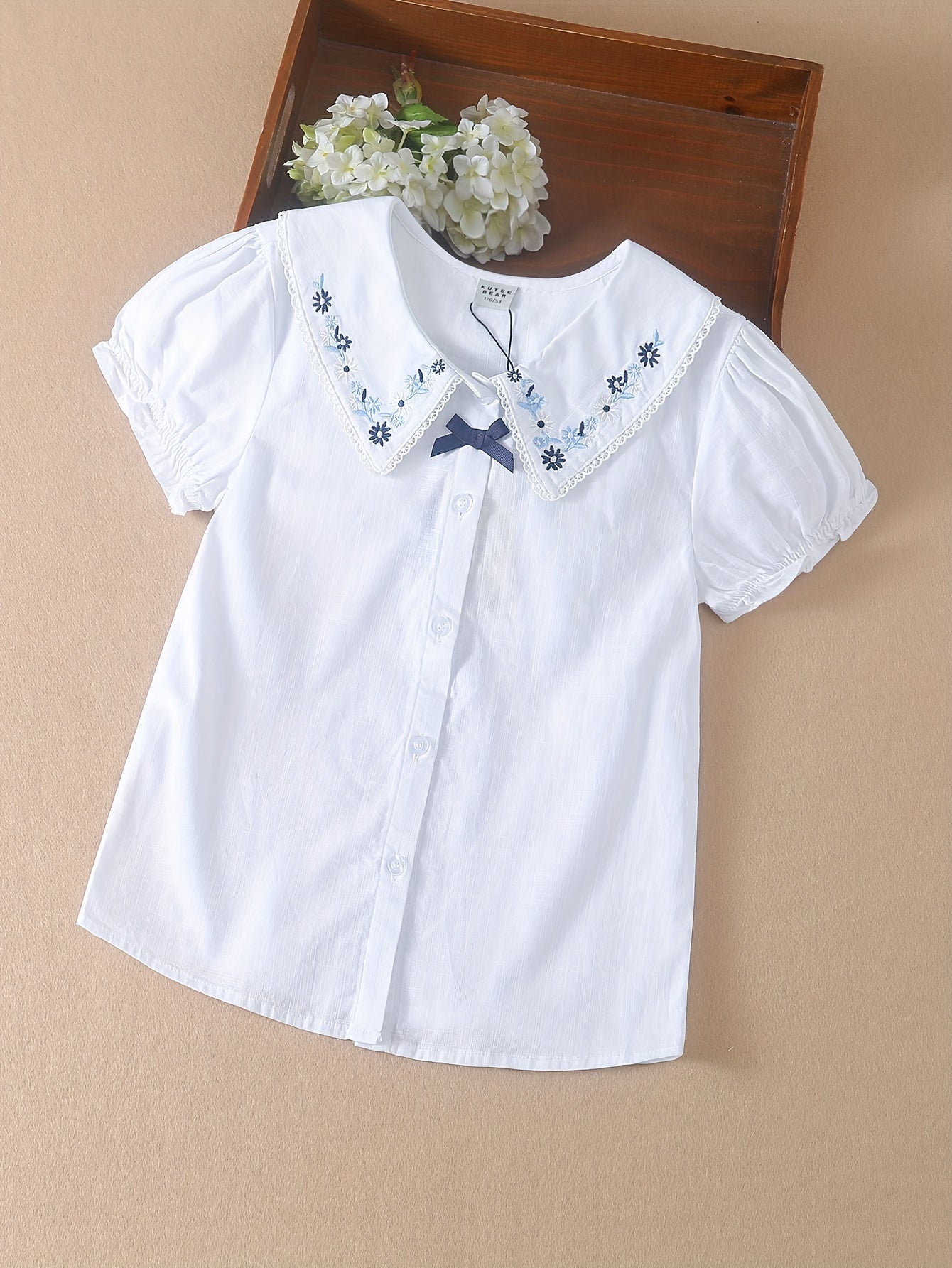 White cotton summer blouse with preppy doll collar, embroidered floral detail, Korean style, for middle and big kids.