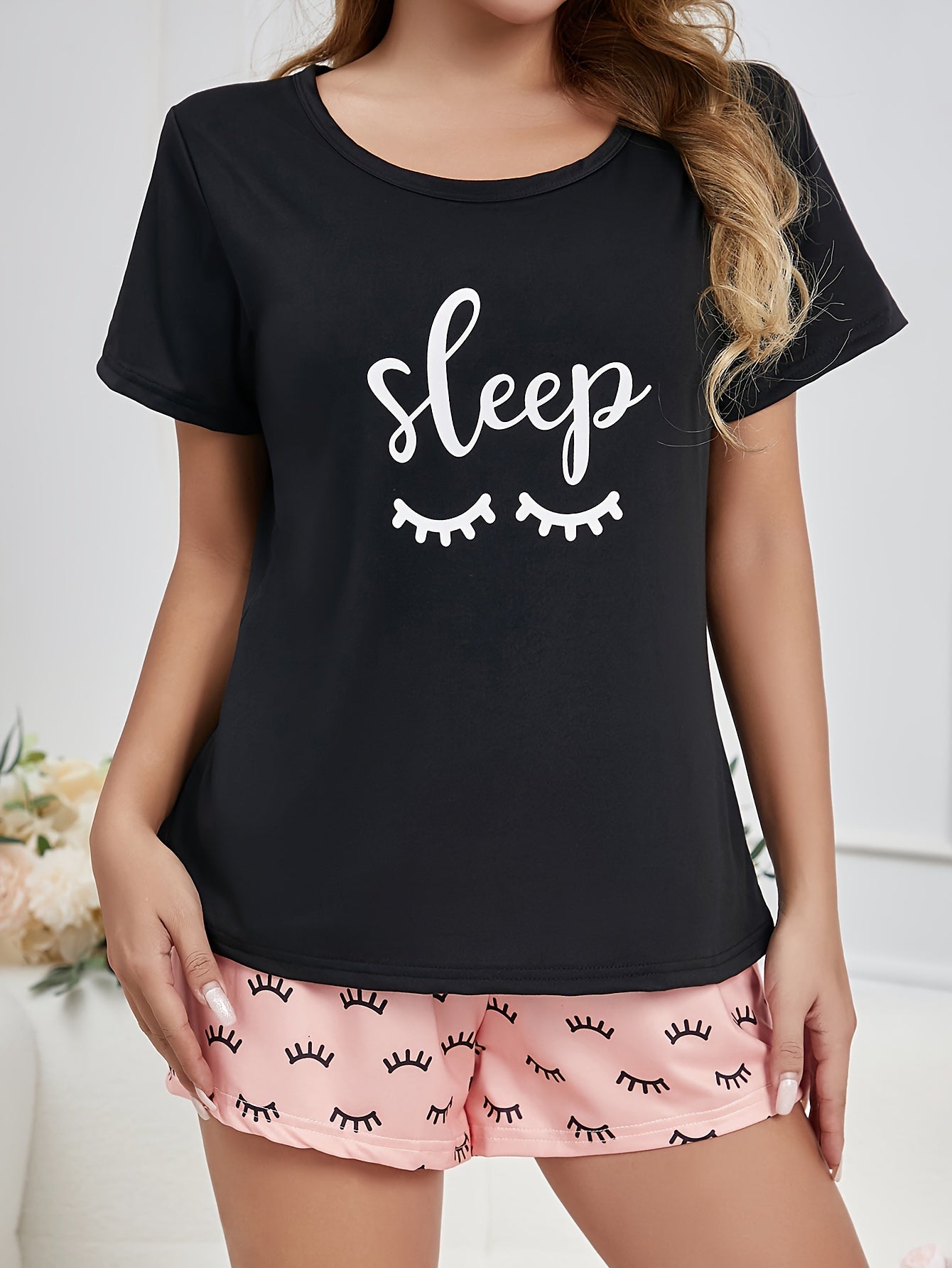 Women's loungewear set featuring eyelash and letter print, including a short-sleeve top and elastic shorts.