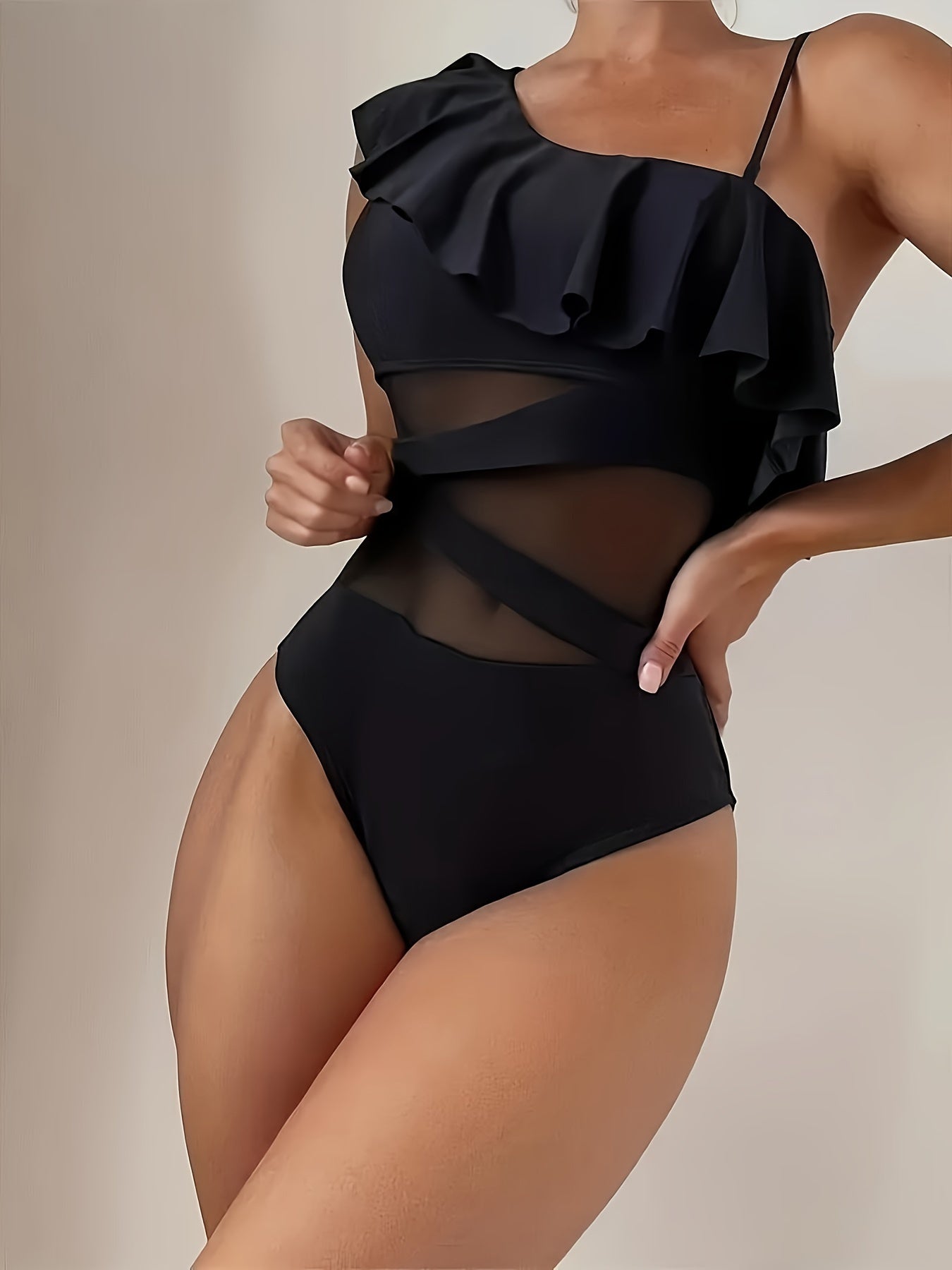 Black one-piece swimsuit with elegant one-shoulder mesh design and ruffle detail.