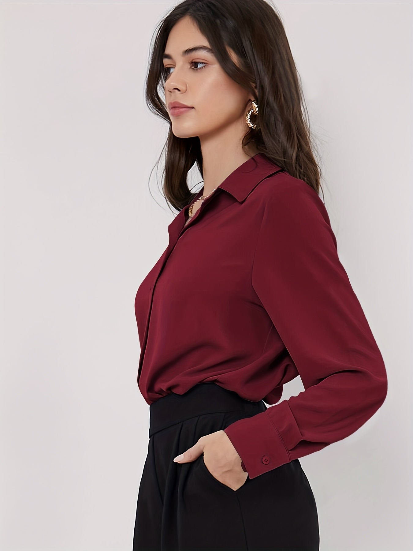 Stylish maroon button-up blouse for women, with long sleeves, curved hem, and made of machine-washable polyester blend. Perfect for work or casual wear.