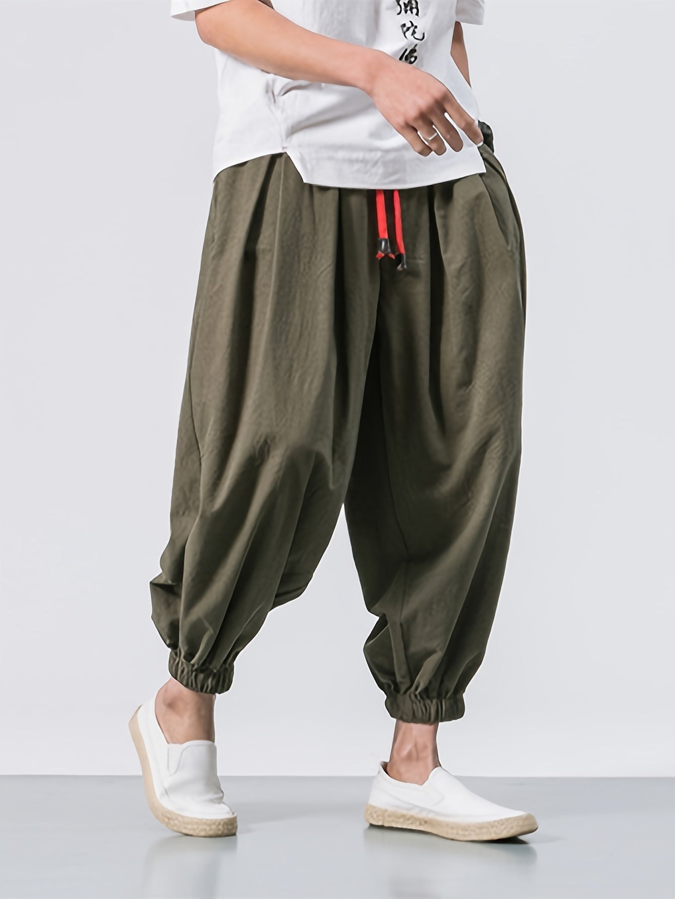 Men's black linen cropped pants with drawstring waist, pockets, and breathable fabric for comfortable wear at home. Ideal for spring and autumn, these stylish pants have a casual, loose fit.