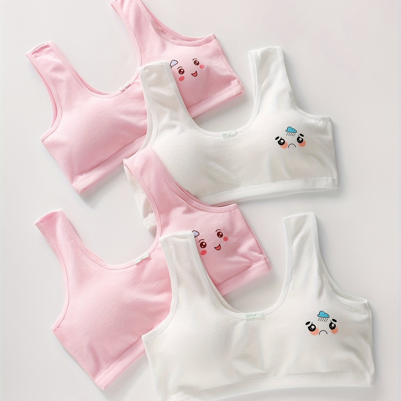 4 comfy cotton bras for girls aged 7-13 with cute animal illustrations in solid colors. Stretchy and machine washable. Includes white, yellow, blue, pink. Ideal for elementary to high