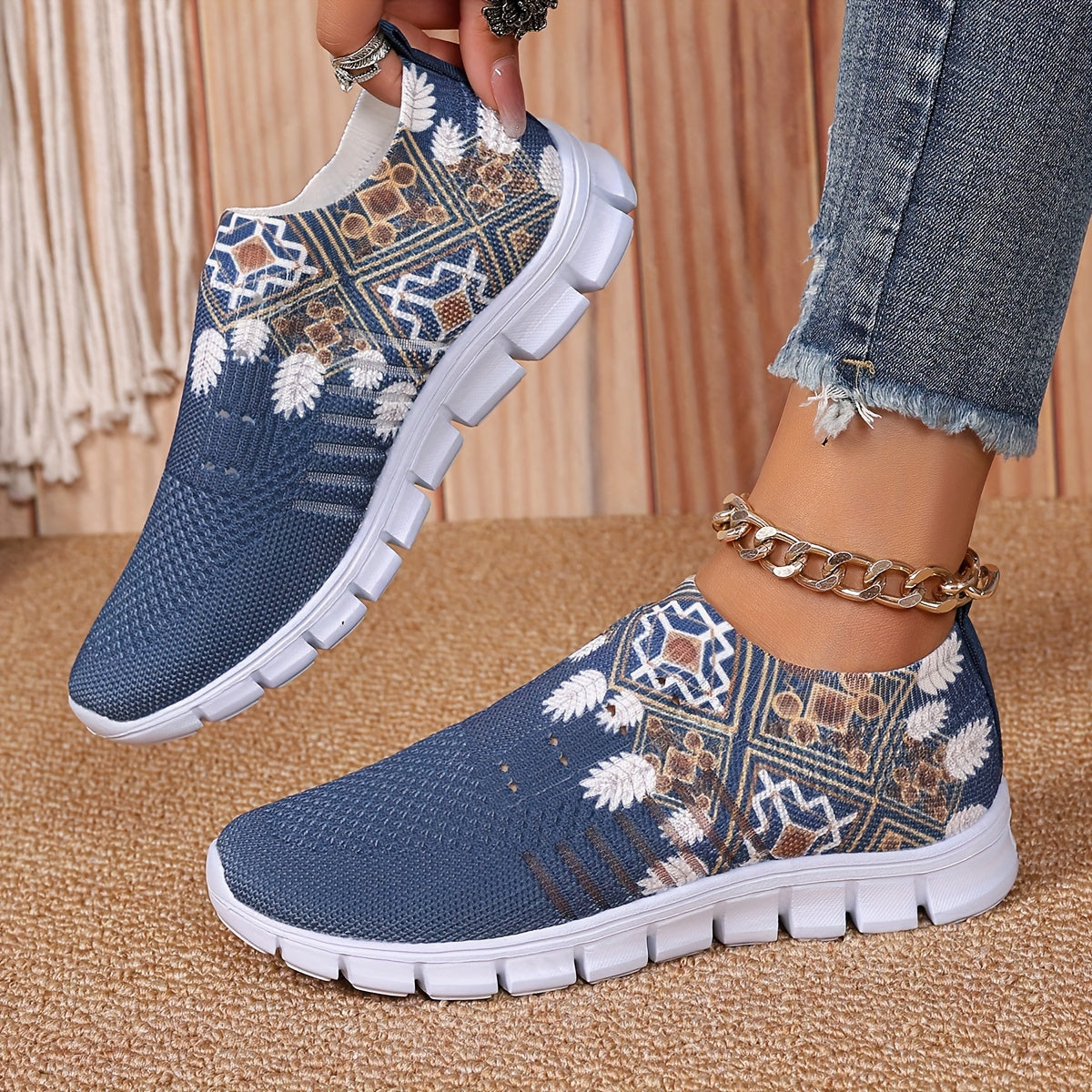 Women's casual slip-on sneakers in blue knit fabric with white floral and geometric patterns, featuring a lightweight EVA sole and breathable low-top design. Perfect for everyday wear with