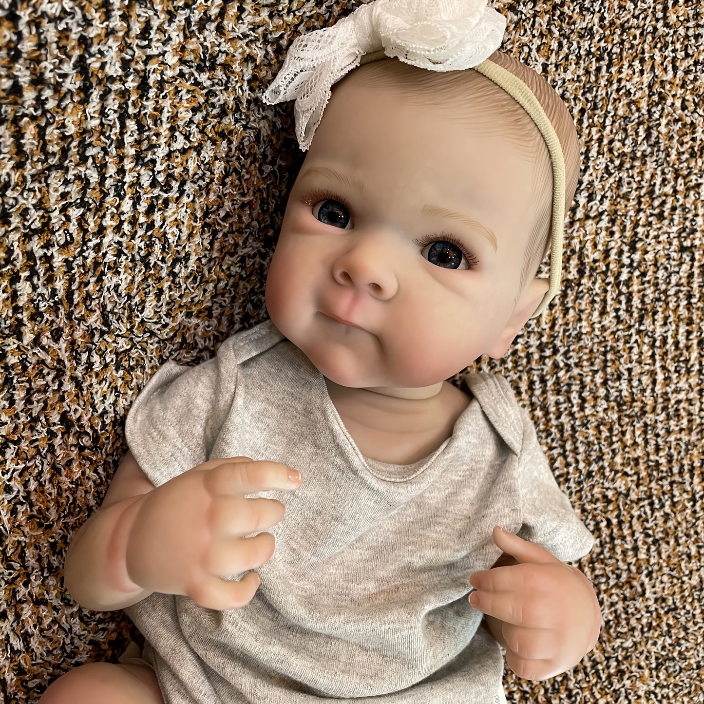 20" lifelike waterproof vinyl reborn girl doll with realistic 3D painted skin and hand-painted hair. Bathable and comes in a comfy gray outfit with headband. Perfect for girls.