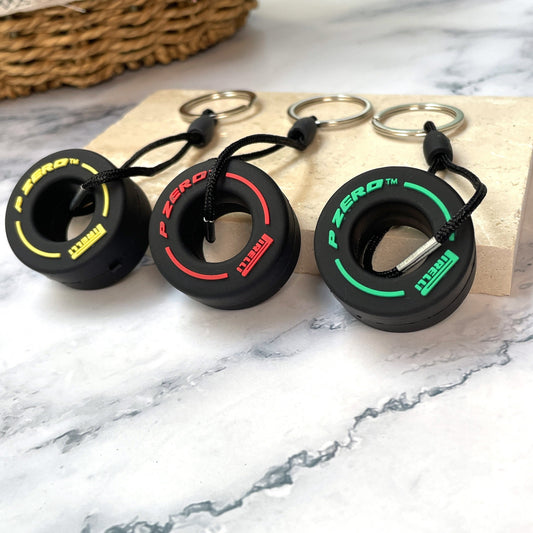 Keychain in the shape of a racing tire available in seven random colors, perfect for both men and women as a decoration for their car keys. Comes in a stylish box for gifting.