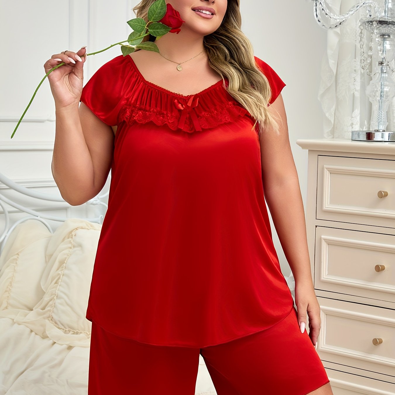 Elegant women's pajama set with bow detail, made of soft polyester and elastane blend. Includes short sleeve top and shorts, easy to care for with machine wash.