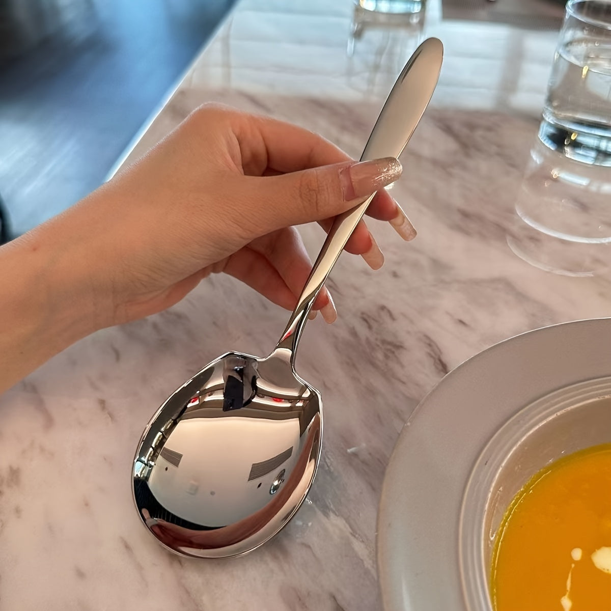 A versatile stainless steel serving spoon for dividing dishes in restaurants, self-serving soup, student dormitories, and large servings in hotels.