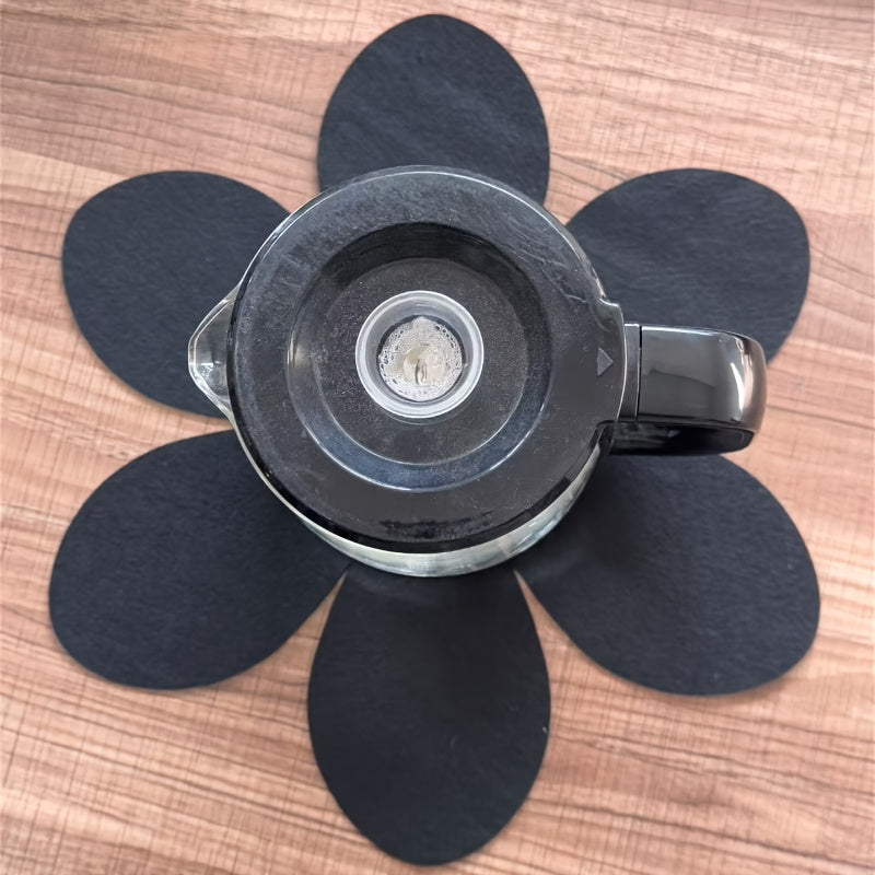 Set of 4 black petal-shaped pan pads made of non-woven, non-stick material. These pads are non-slip, anti-scalding, and provide heat insulation. They are easy to clean and made of multi-ply felt cloth.