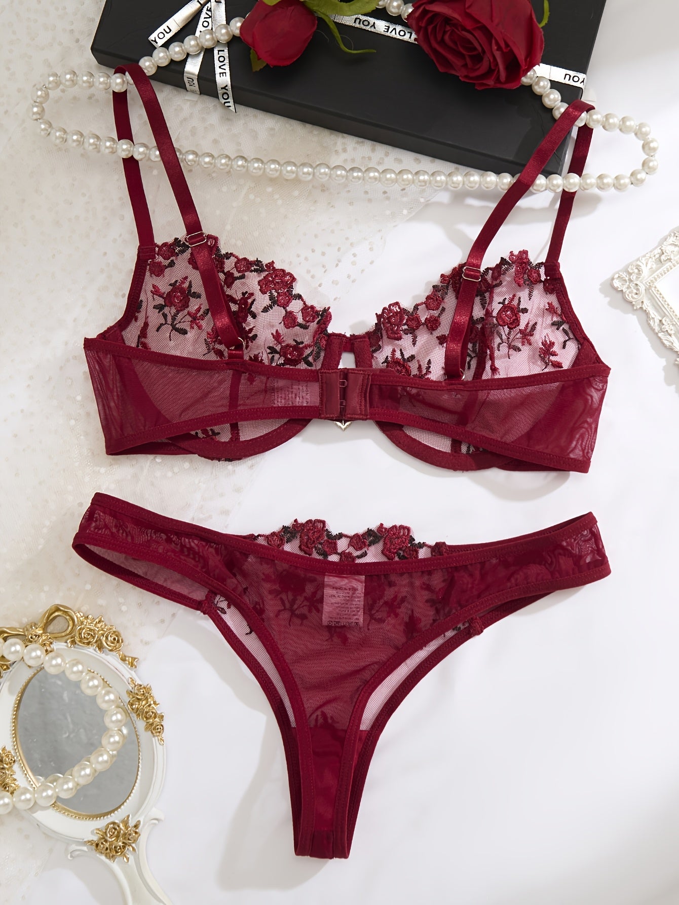 Red floral embroidered lingerie set for women with sheer mesh bra and low-rise panties. Hand washable, made from polyester and elastane blend.