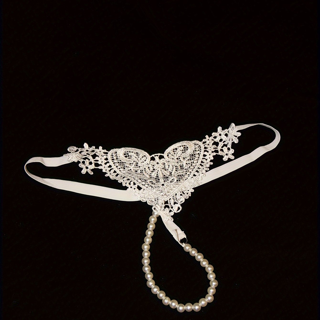 Low-rise thong with pearl embellishments and hollow out design. Breathable polyester, hand washable. Ideal for adults.