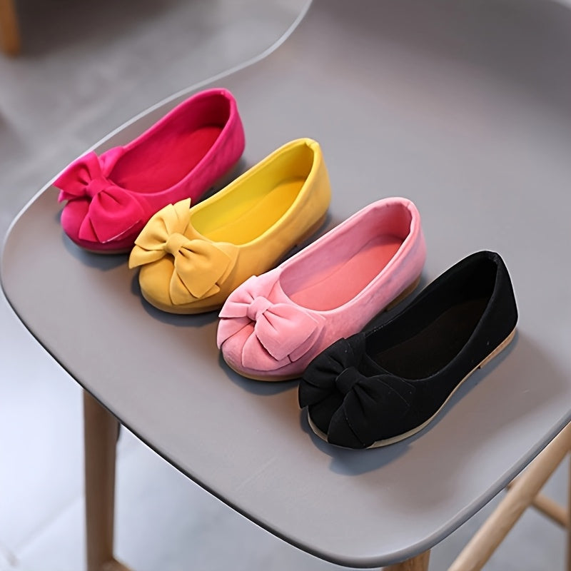 Stylish slip-on princess shoes for chic girls in pink, yellow, and black, with a bow detail. Made of comfy PU fabric with a rubber sole. Easy slip-on design for casual attire and