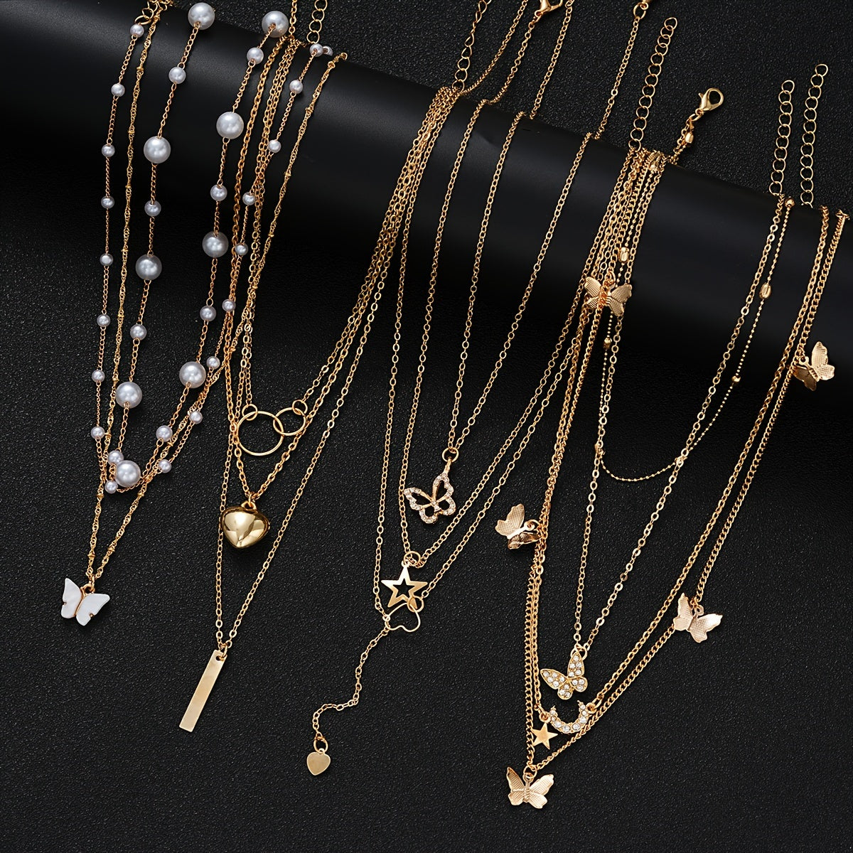 Set of 11 pieces featuring faux pearl and rhinestone star, butterfly, and heart necklaces for women. This fashion stacking jewelry set is perfect for daily wear, dates, holidays, and parties. Ideal for adding a simple and vacation style to any outfit.