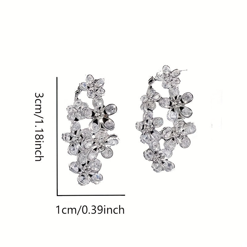 Silvery and elegant, these C-shaped flower hoop earrings are adorned with exquisite details, giving them a bling-bling style that is perfect for any occasion. Made of copper, this versatile piece can be worn as jewelry or used as a stylish ornament.