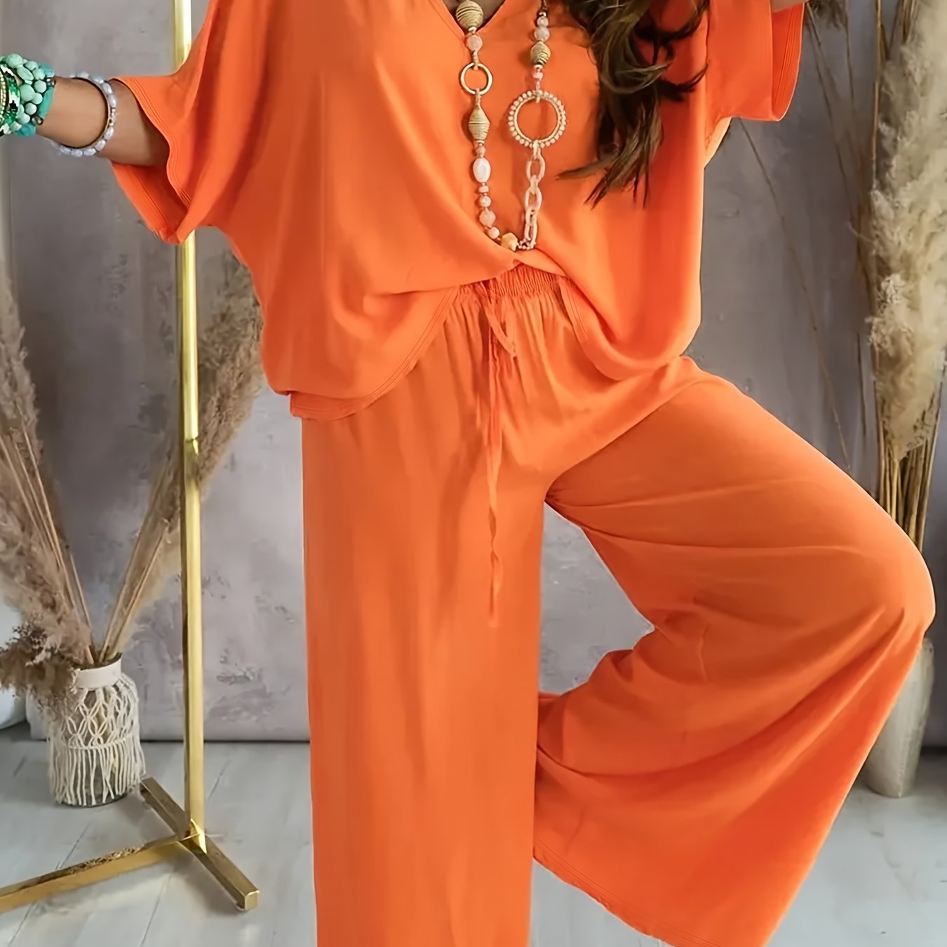 Women's clothing set with solid color pants, half sleeve V neck top, and wide leg pants.