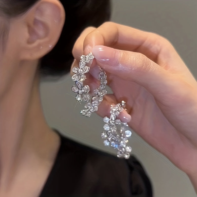 Silvery and elegant, these C-shaped flower hoop earrings are adorned with exquisite details, giving them a bling-bling style that is perfect for any occasion. Made of copper, this versatile piece can be worn as jewelry or used as a stylish ornament.