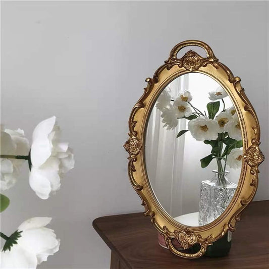 Portable vintage floor mirror tray with handle for vanity makeup use in home bathrooms. Elegant ornate frame design, no electricity required.