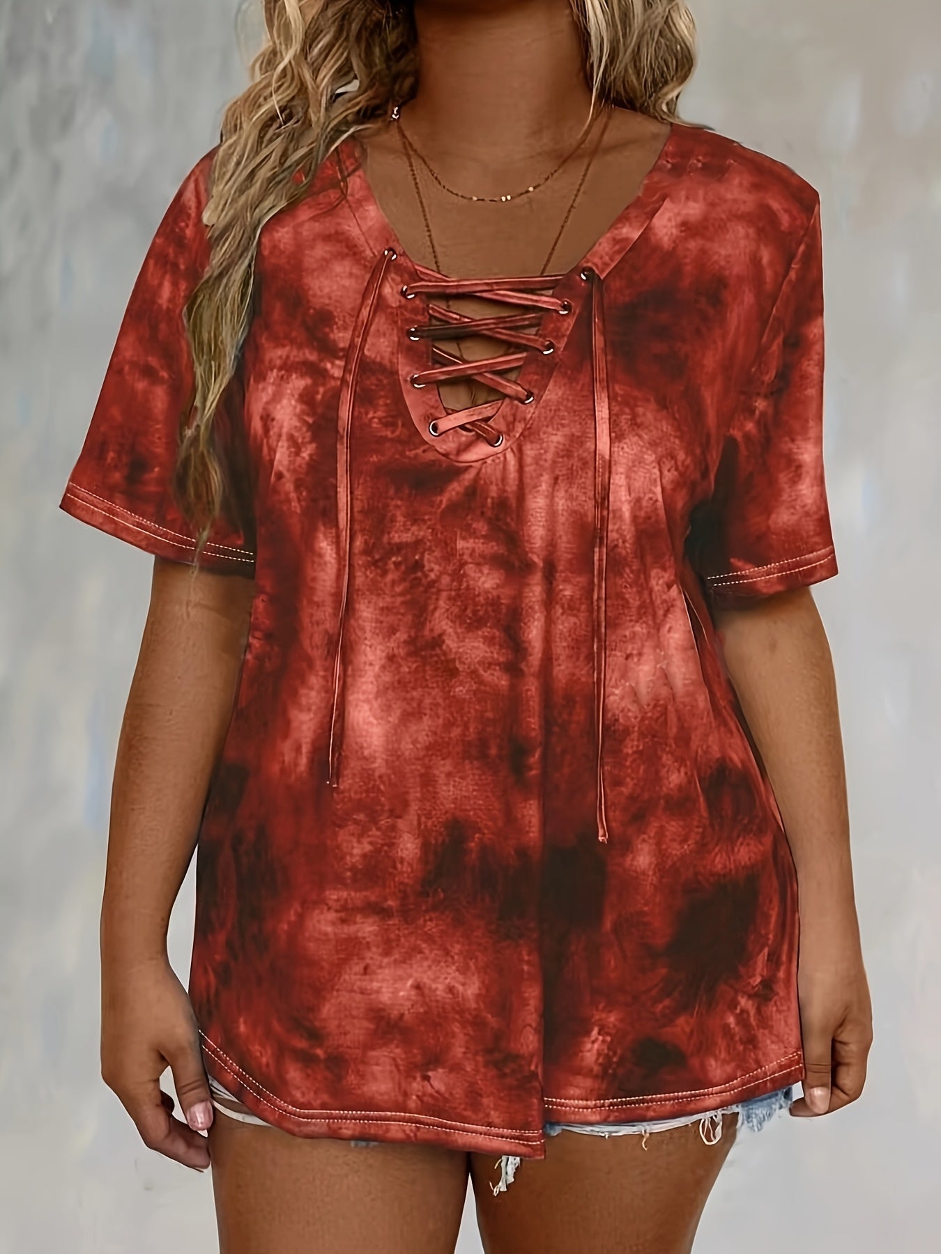 Plus size tie dye print t-shirt for women, made of polyester knit fabric with spandex. Features a lace-up drape neck detail and medium stretch. Ideal for spring/summer casual wear.