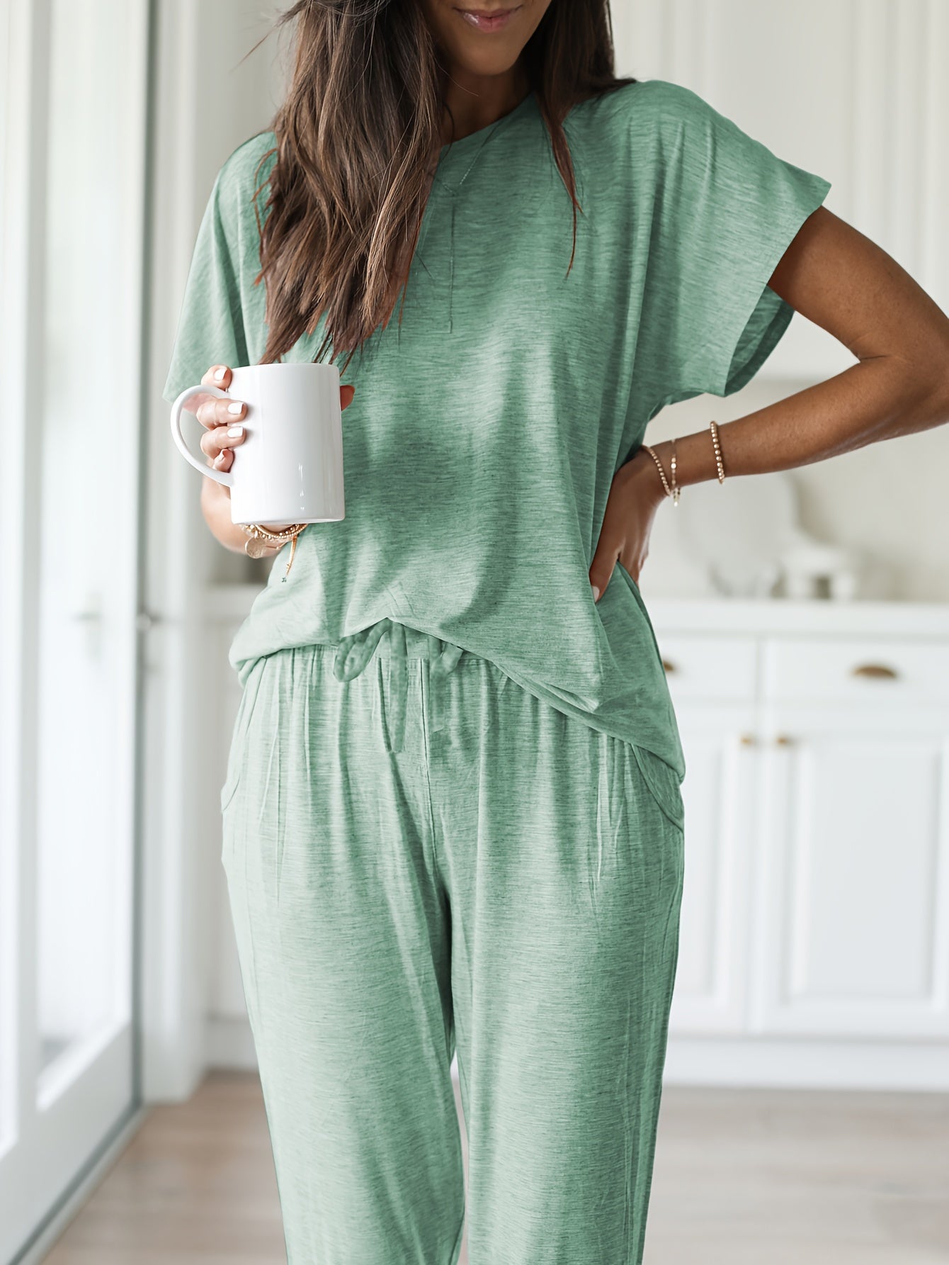 Light pink loungewear set for women includes a short sleeve top and long pants. Made from stretchy, machine washable polyester blend with pockets - perfect for all seasons.