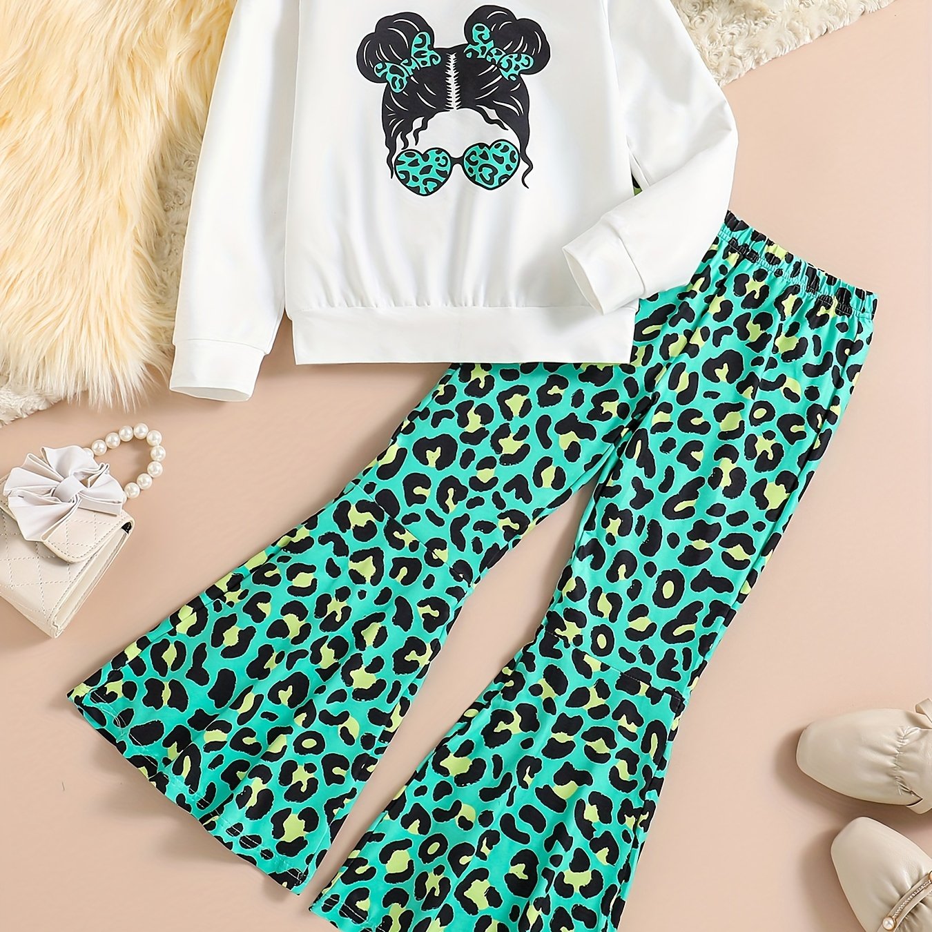 Girls' trendy 2-piece outfit includes a sweatshirt, leopard pattern flared pants, and sunglasses print. Perfect for spring and fall outdoor wear.