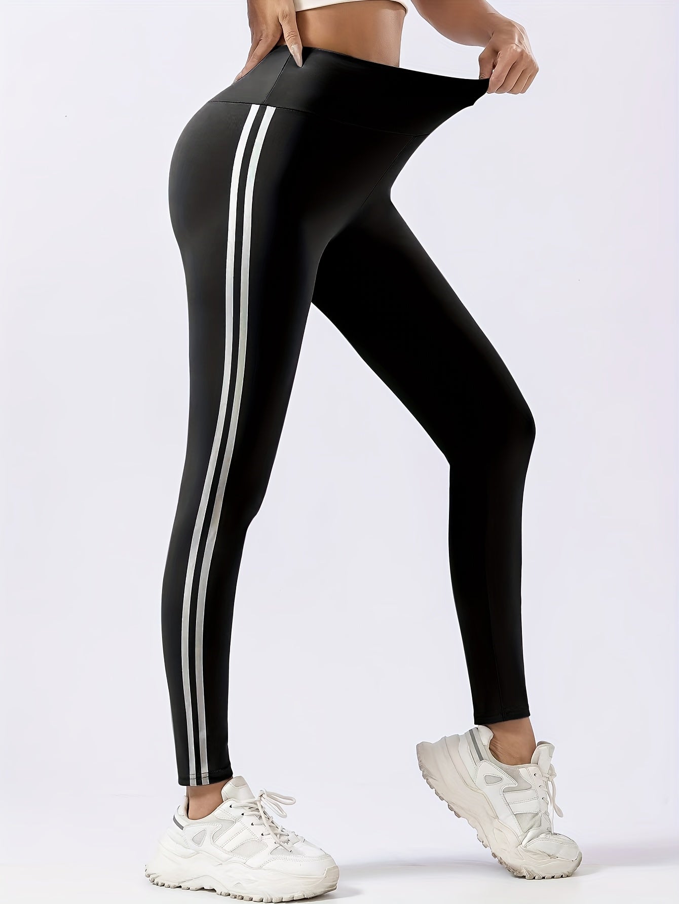 Women's chic black leggings with white side stripes, high-waist design, butt lifting, and tummy control features. Made with quick-dry and breathable fabric for a slimming effect. Machine