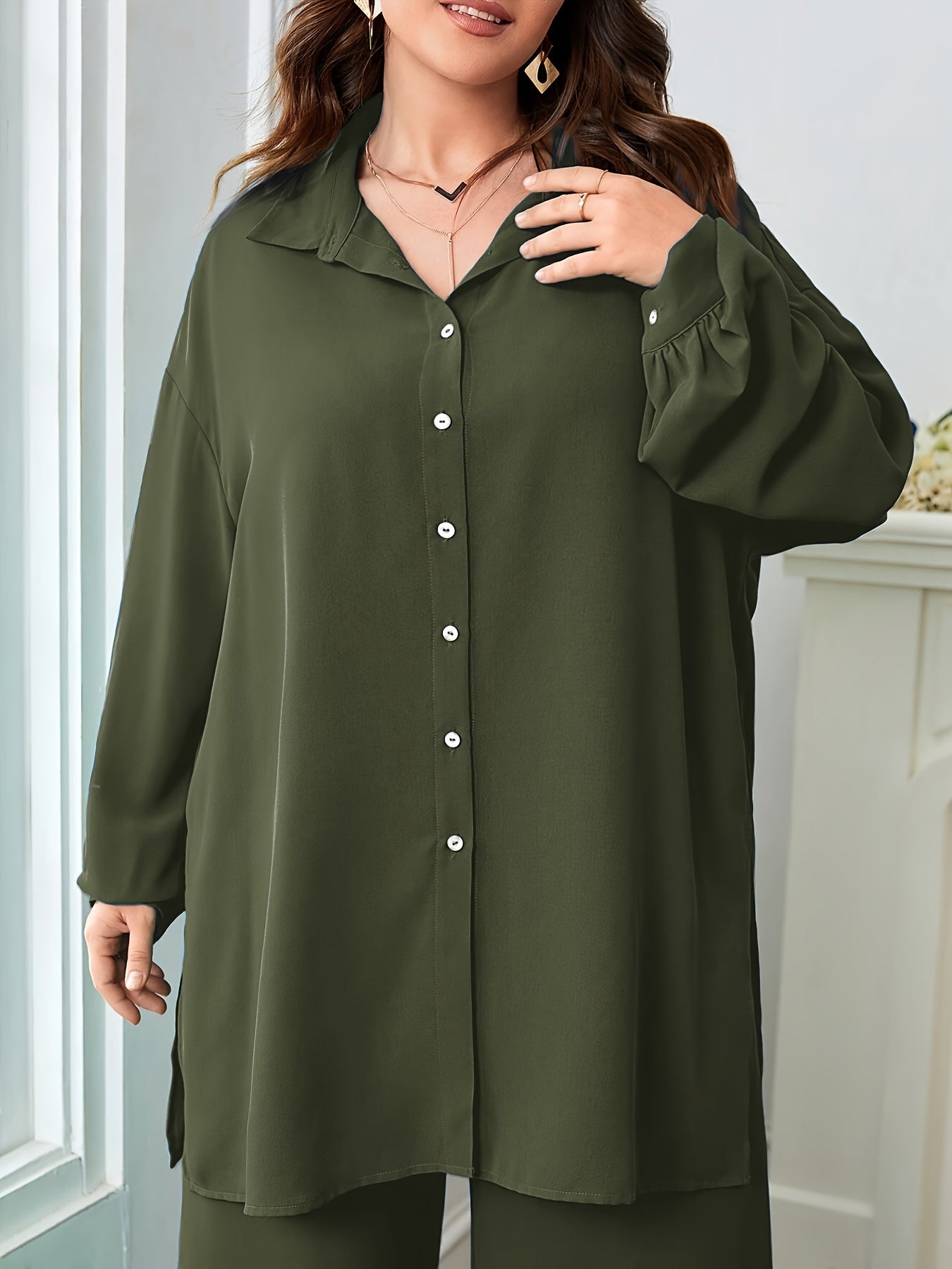 Black polyester blend pants with split details and a relaxed blouse comprise an elegant oversized V-neck two-piece set.