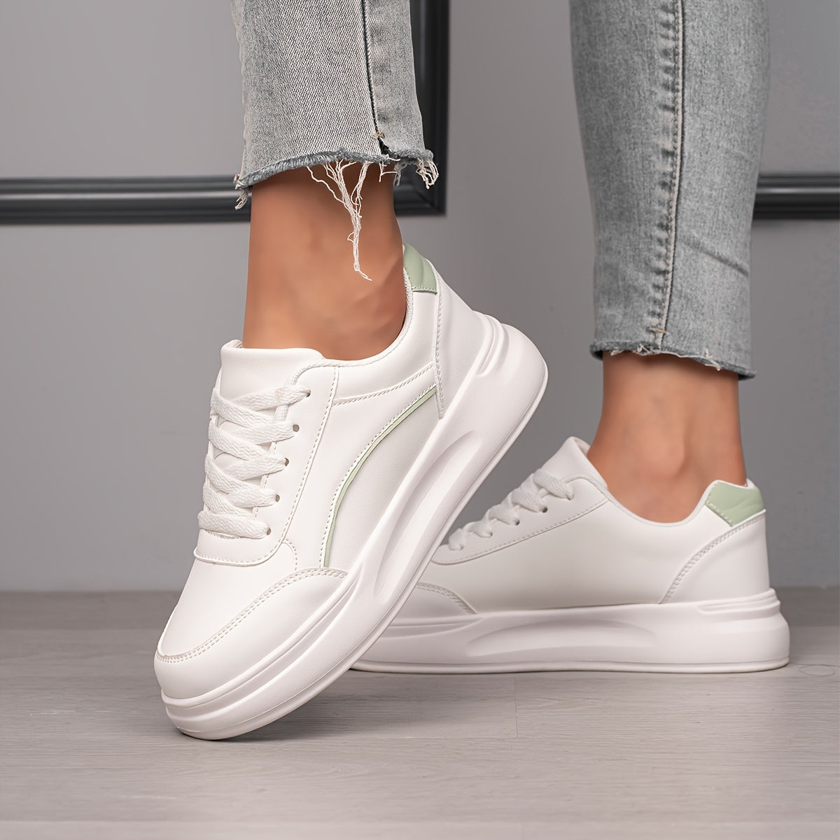 Women's white skate shoes with round toe, lace up closure, and low top flat design. Comfortable for casual wear and sports.