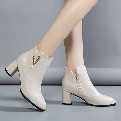 White ankle boots for women with chunky heel, faux cover, round toe, side zipper, buckle detail, fabric lining, rubber sole, and high heel.