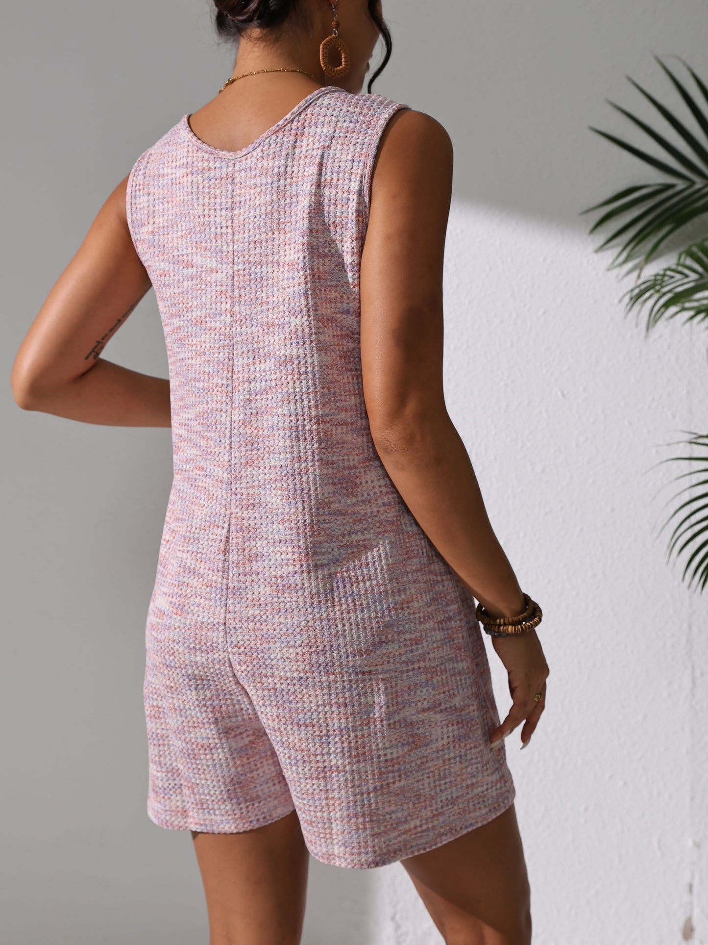 Sleeveless waffle knit romper with pockets for plus-size women in pastel pink. Comfortable and stretchy, perfect for spring/summer.