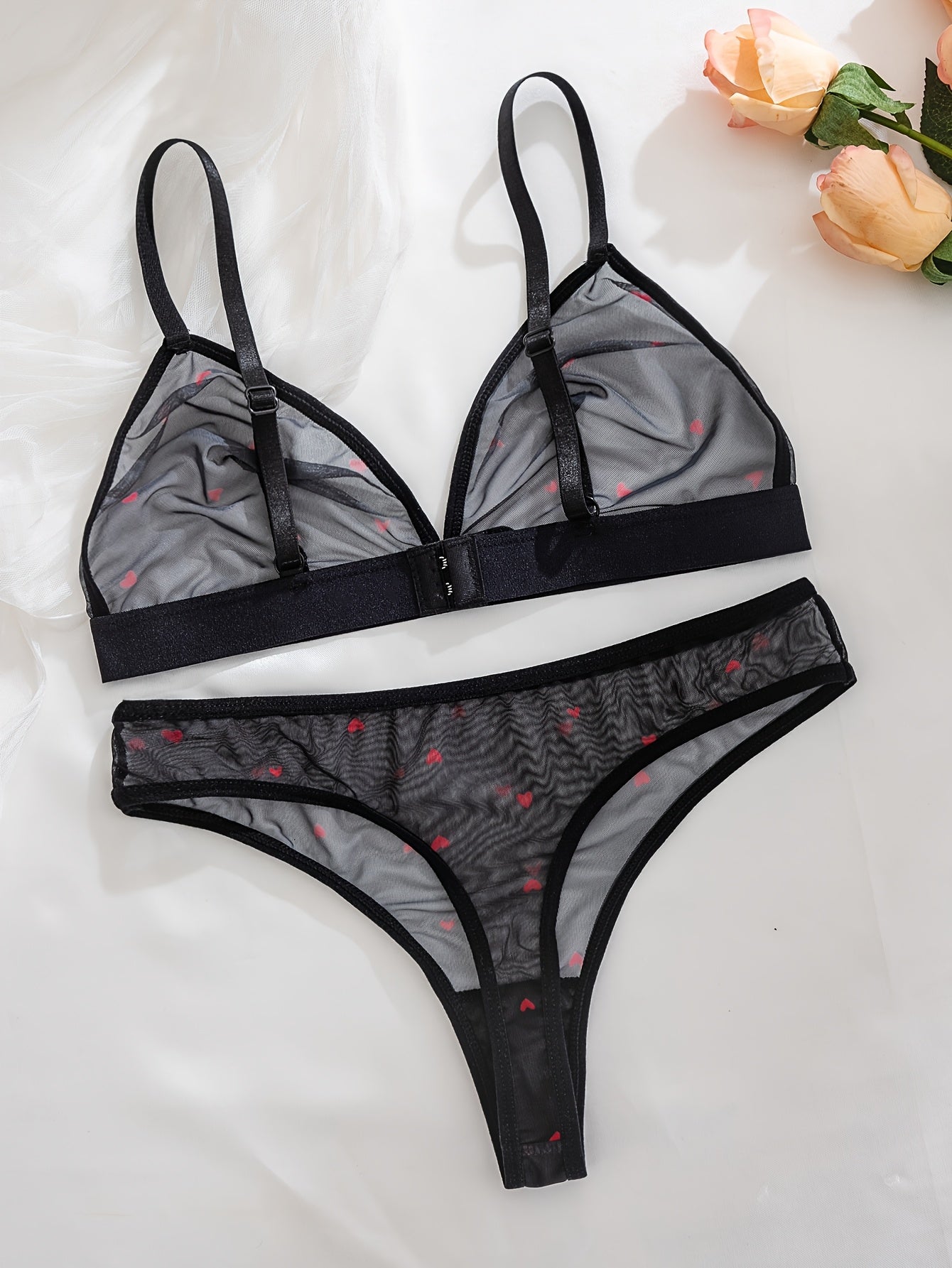 Sexy black sheer mesh lingerie set with red heart pattern, medium support, no underwire, drop waist, made of 90% polyester and 10% elastane.