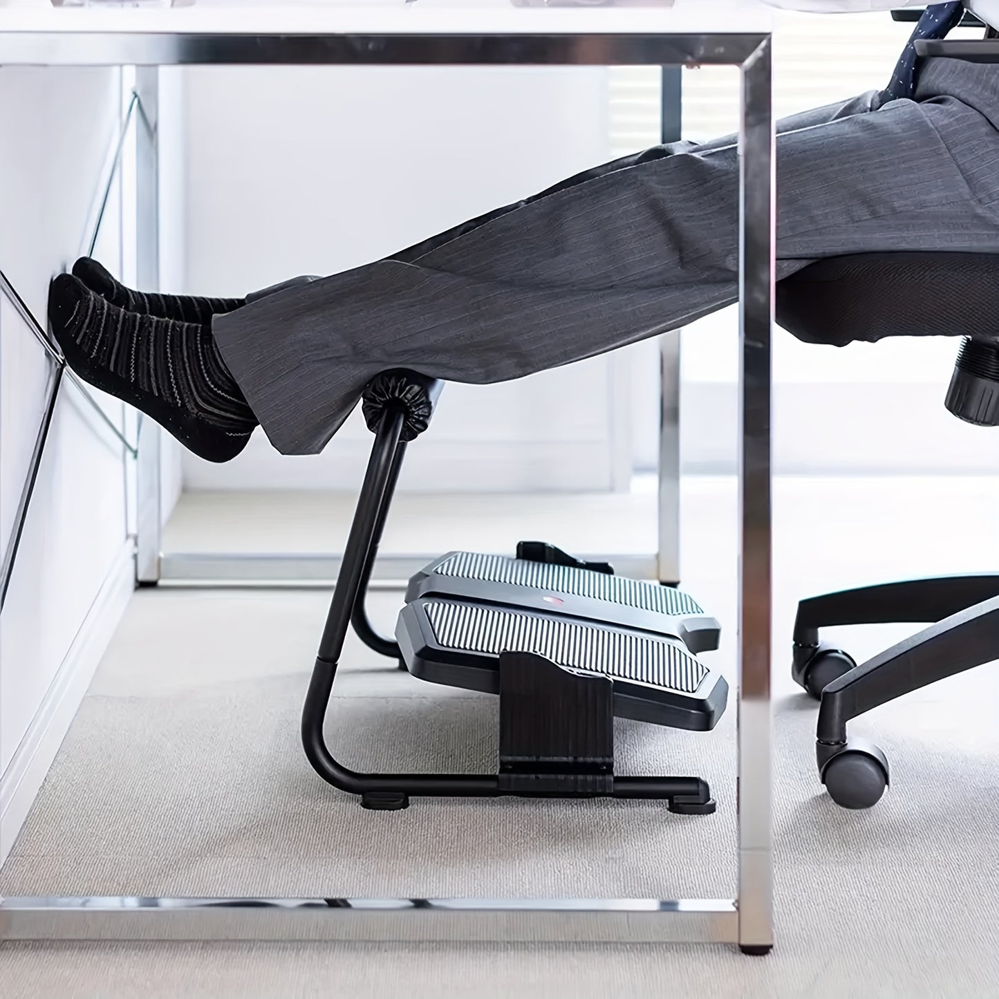 Adjustable ergonomic footrest stool for office use, non-electric, black plastic material.