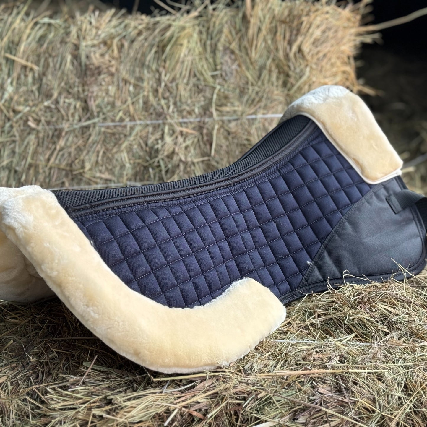 English saddle horse half pad with 100% woven fabric outer and shape-retaining foam insert, featuring a thick, soft, non-shedding synthetic sheepskin for easy cleaning.