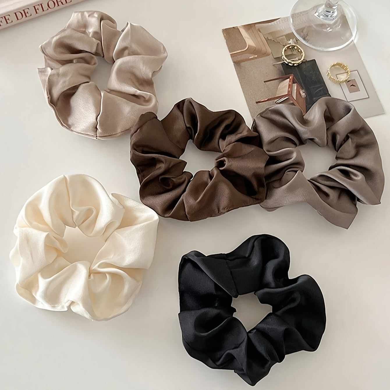 5 elegant and versatile hair scrunchies in classic black, white, and brown suited for all ages.