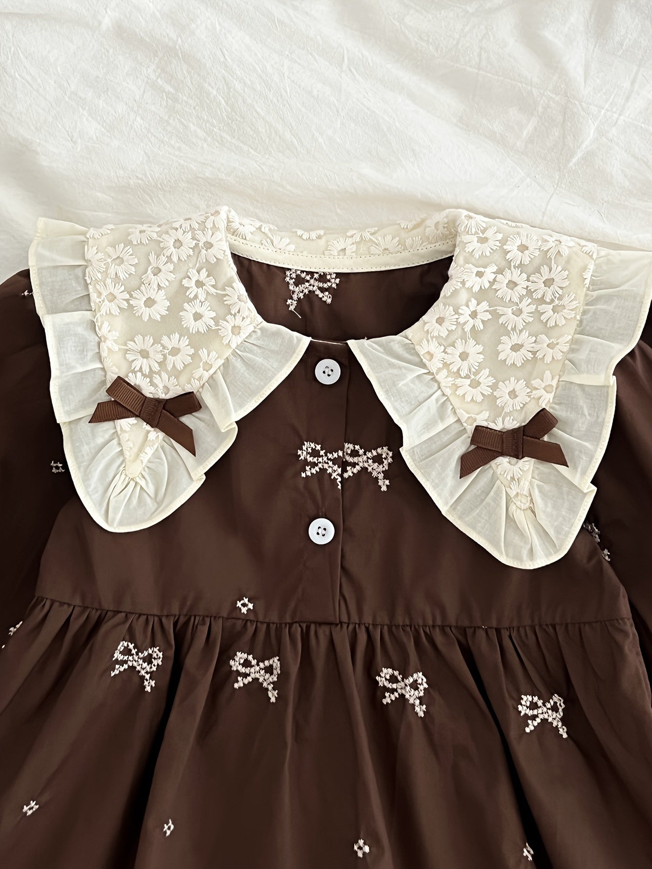 Stylish floral embroidered long-sleeve romper for baby girls, made of cotton with bow detail, ideal for spring/fall and outdoor wear.