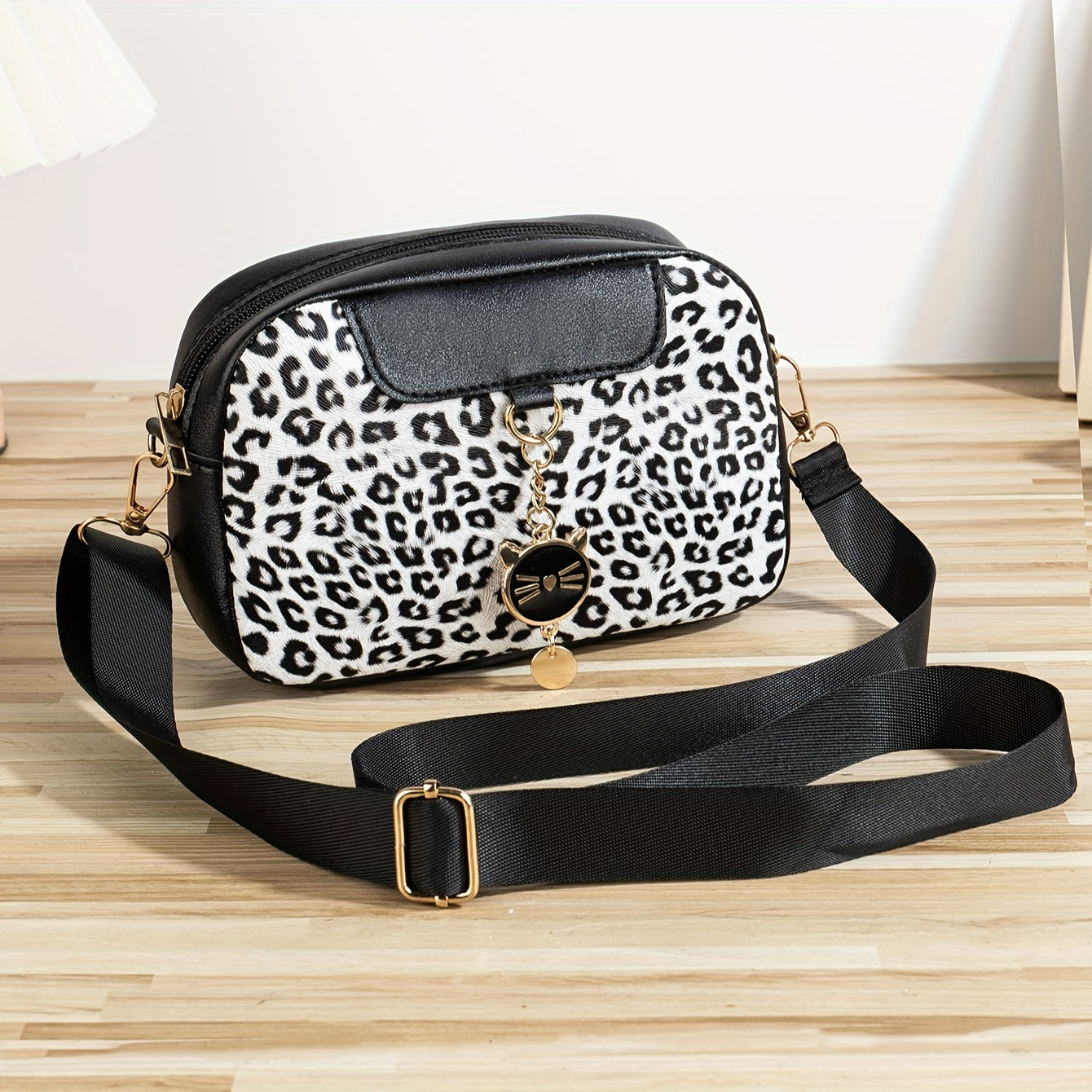 Chic leopard print crossbody bag with adjustable strap, cat charm, zip closure, and polyester lining - ideal for work, outings, and daily commutes.