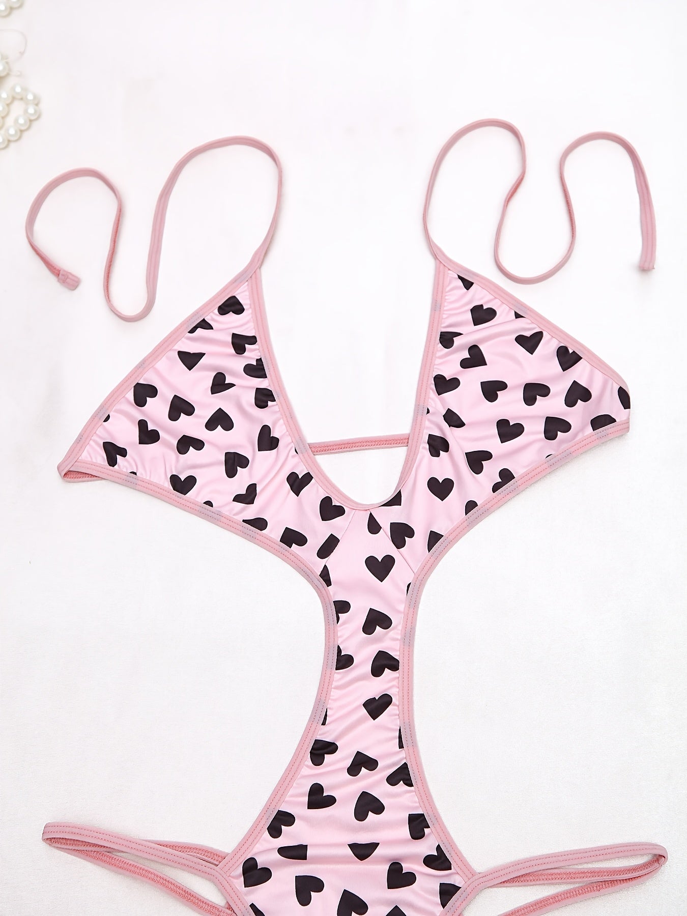 Women's sexy heart pattern bodysuit made of 90% polyamide and 10% elastane knit fabric, ideal for adults.