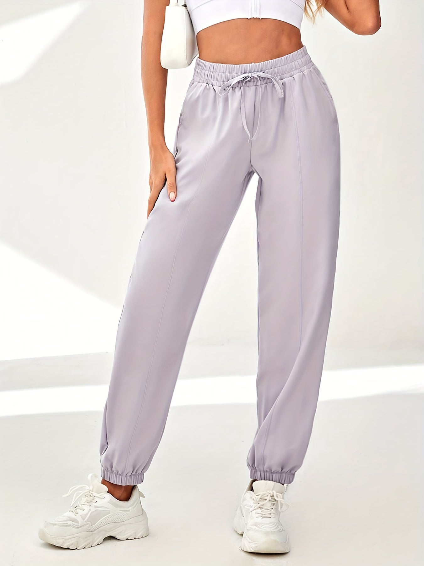 Solid color quick-drying sweatpants with drawstring elastic waist for women's athleisure.