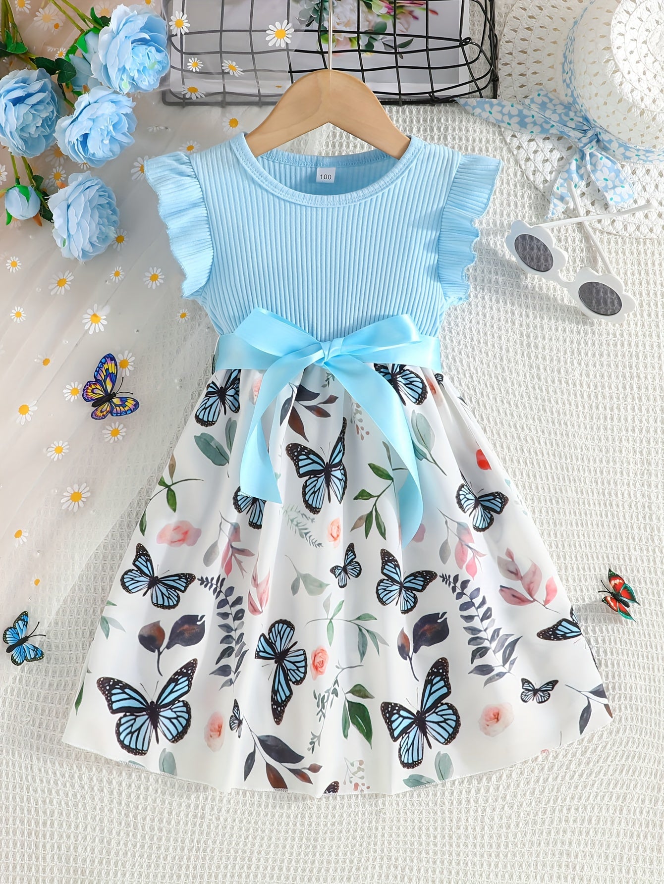 Girls' light blue ribbed cotton dress with butterfly & floral print, flutter sleeves & belt detail. Casual summer wear, machine washable. Dresses for girls.