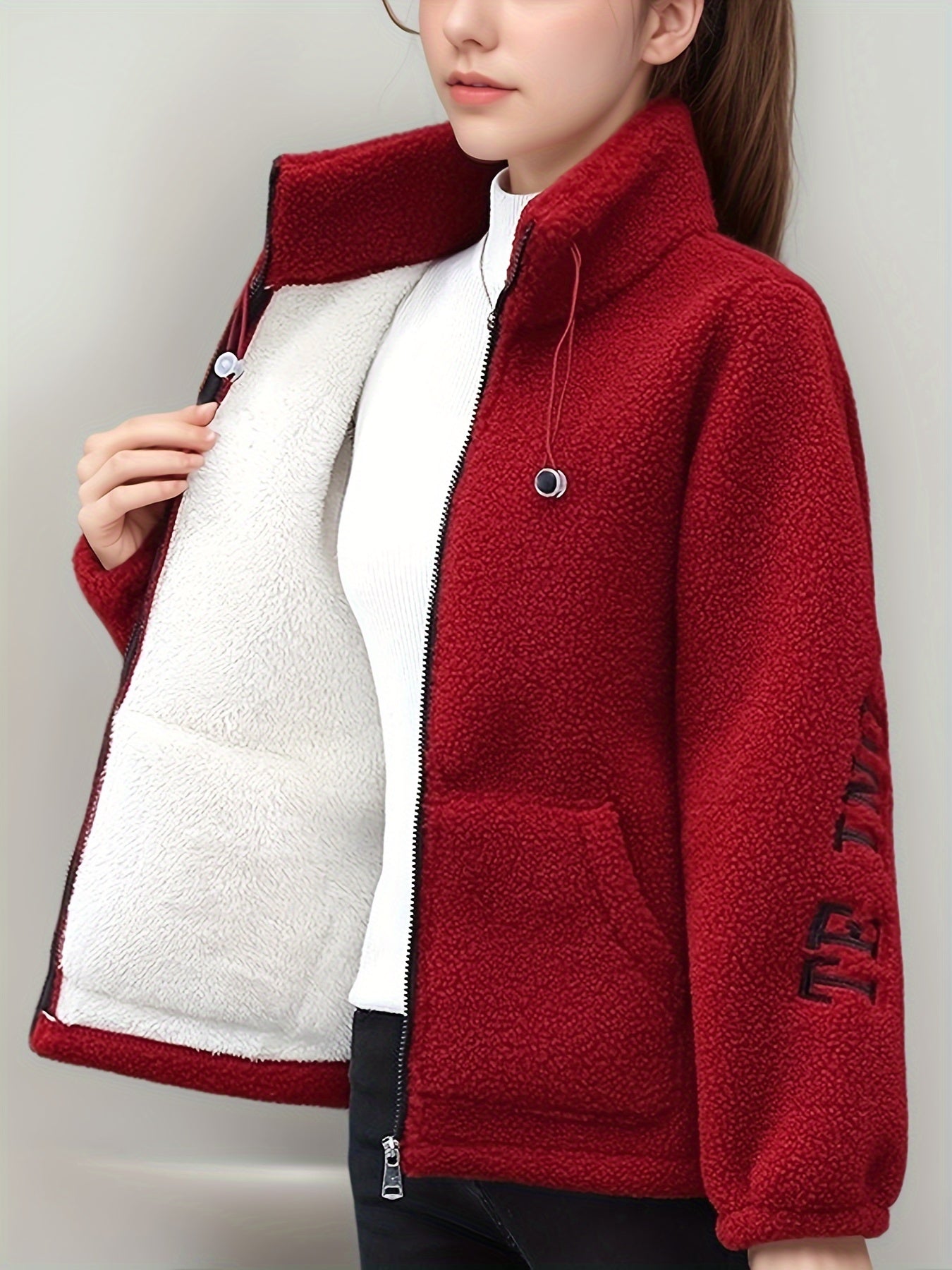 Cozy fleece-like jacket for women with embroidered letters in warm red velvet, perfect for all seasons. Cute and casual with a stand collar, long sleeves, and fleecelike texture.