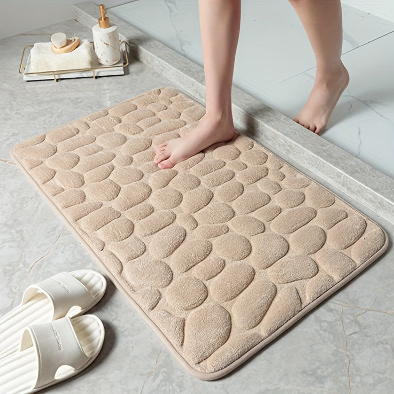 The Coral Fleece Non-Slip Bath Mat features a pebble design and is made of memory foam for ultimate comfort. This machine-washable bathroom rug has a solid pattern, flat woven construction, and low pile for easy care. It has a weight of 400gsm and comes