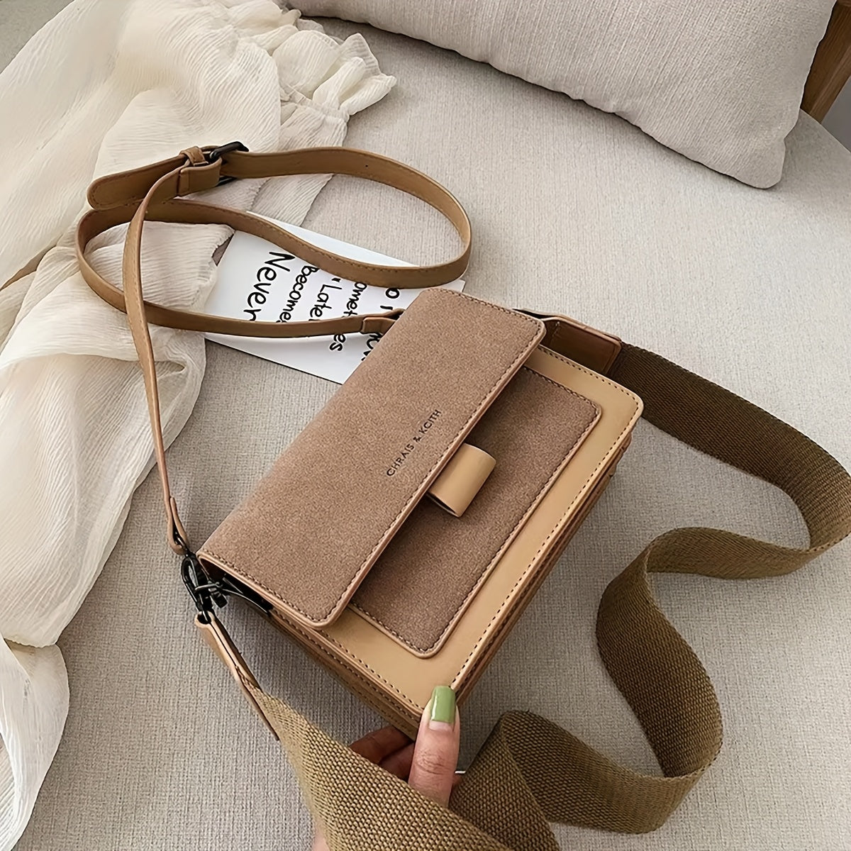 Elegant beige and brown crossbody bag with adjustable strap for everyday use, featuring a stylish geometric shape and magnetic closure.