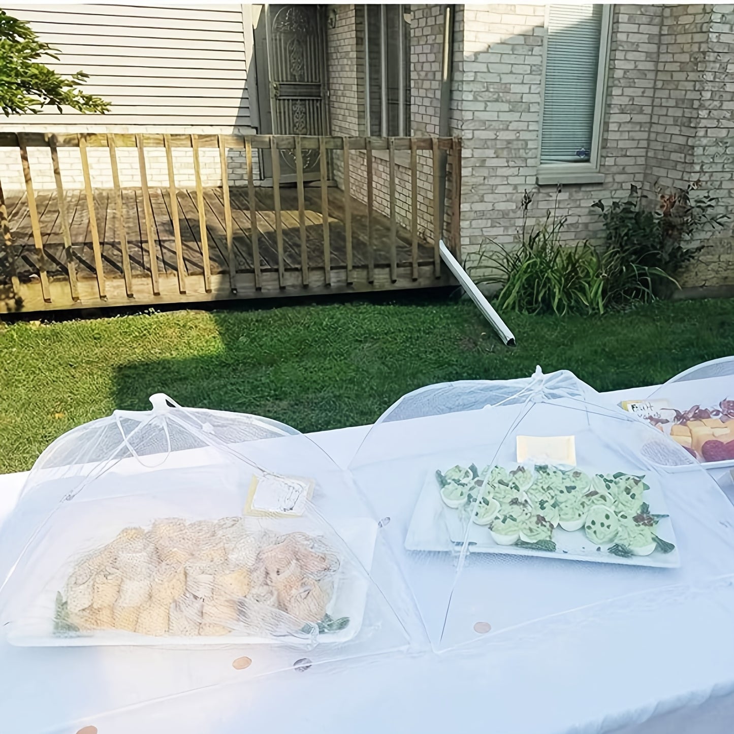 Foldable white mesh food cover tent, perfect for outdoor picnics, BBQs & parties. Protects from insects and ideal for breakfast spreads. Portable and washable.